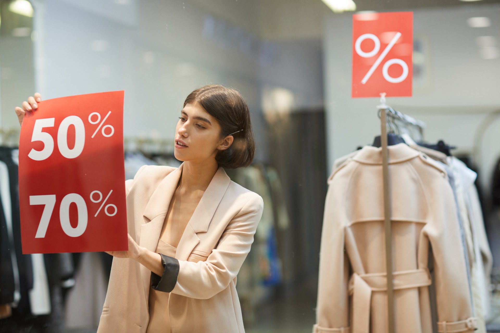 Woman Hanging Sale Signs in Store